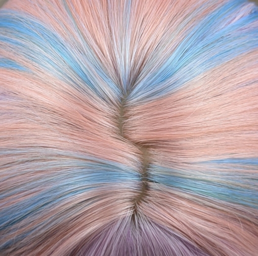 Confetti - Lush Wigs UK Confetti is a mixture of many pastel colours. Peach, lilacs, blues and greens. Long and curly with invisible layers for bounce and a full sleek pink fringe.