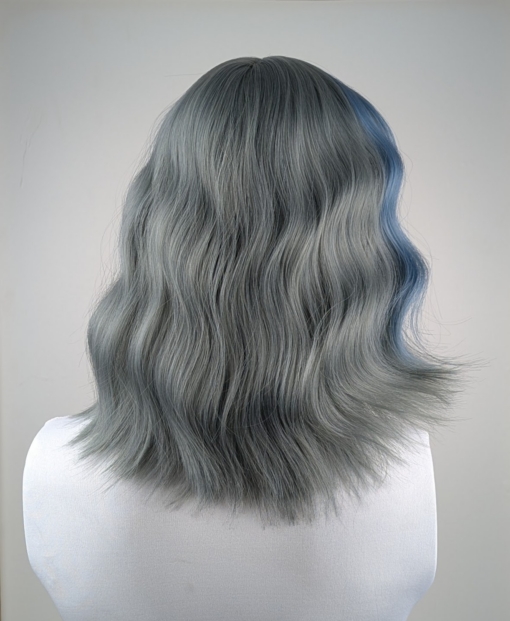This long bob styled into flat iron waves comes in a mix of dark green and denim blue. Resulting in a wash out effect on colour. A block of blue colour frames the face. The fringe is sleek.