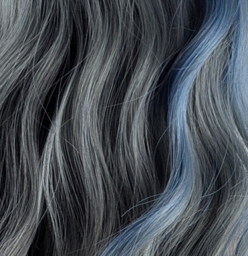 This long bob styled into flat iron waves comes in a mix of dark green and denim blue. Resulting in a wash out effect on colour. A block of blue colour frames the face. The fringe is sleek.