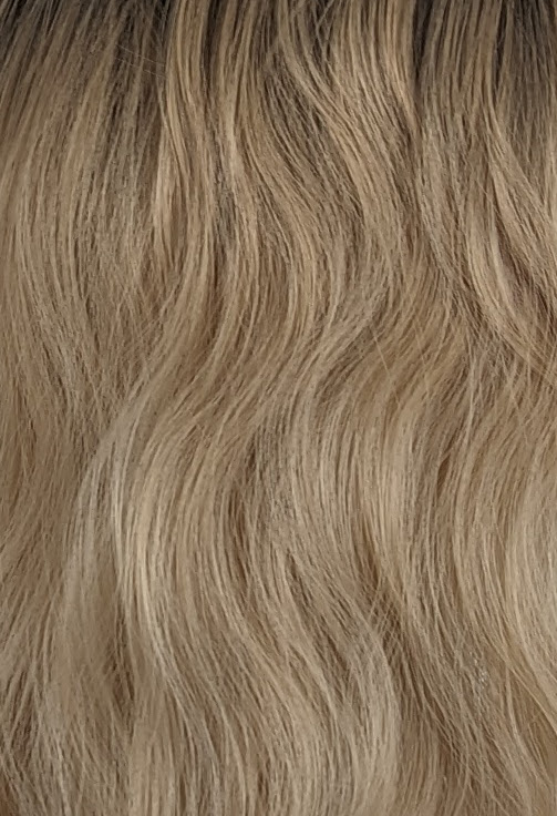 Eleri - Lush Wigs UK This long bob with dark brown shadow roots blend into a warm blonde hue. Styled in a loose wave with a sleek blunt fringe.