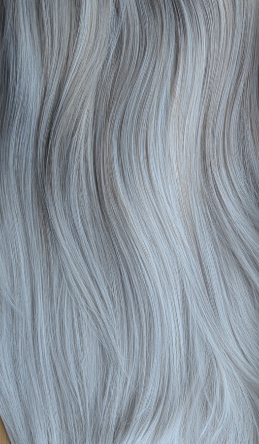 January - Lush Wigs UK A natural wig with dark brown shadow roots that blend into a mix of platinum blonde and sandy blonde. These two tones blend to create a mushroom hue.The ends of the hair are pure platinum blonde. The style is long and sleek with layers at the front with a blunt fringe.
