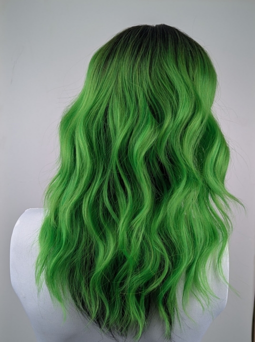 Lagoon - Lush Wigs UK Green and bold. Dark brown roots blend into this bright two tone green colour, with a slice of dark brown at the nape of the neck. For a peek-a-boo effect. Styled into a loose wave with a blunt fringe.