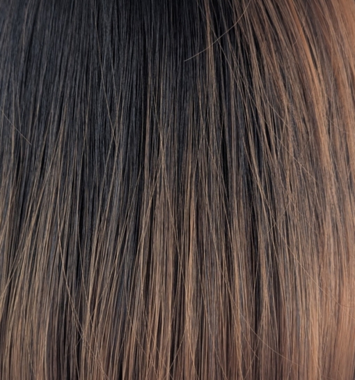 Lucia is a sleek bob that curls under at the ends. Falling to the jawline. This black/brown colour has highlights of copper tones that bring it to life. With a sleek full blunt fringe.