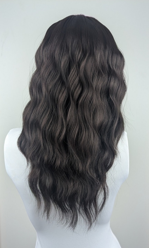 This natural medium length wig comes in a very dark mix of black and a deep brown cocoa tone. From roots to tips. Styled in loose tousled waves with layers and a blunt sleek fringe.