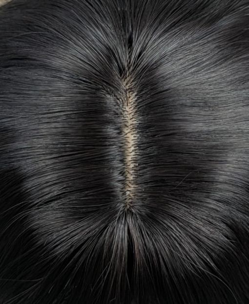 This natural medium length wig comes in a very dark mix of black and a deep brown cocoa tone. From roots to tips. Styled in loose tousled waves with layers and a blunt sleek fringe.