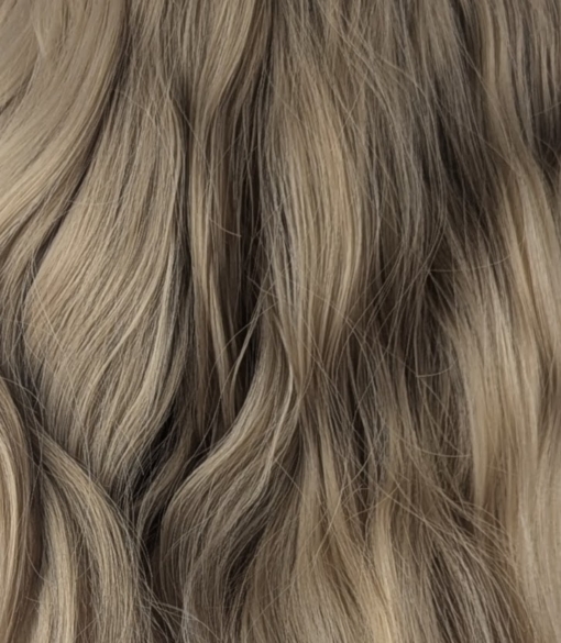 This bob is styled into loose tousled waves with plenty of volume. A light blonde shade from roots to tips. With a sleek blunt fringe 