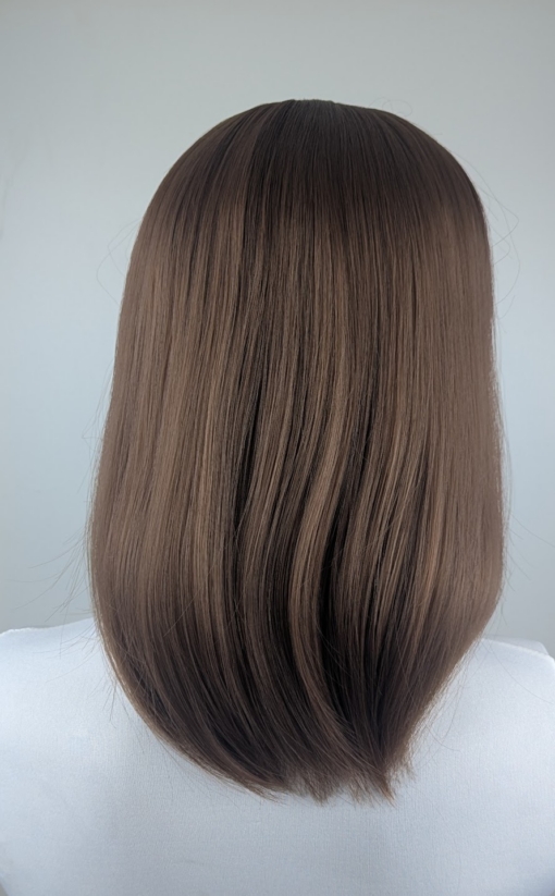 This natural brown colour wig is simple and easy to wear. Its rich brown shades come to life with golden-copper undertones. A sleek long bob (lob) that curls just under at the ends. With a light sleek fringe.