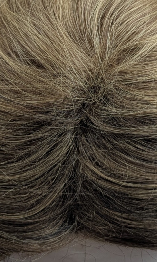 This curly fringe-less short-bob has natural brown shadow roots that blend into honey blonde tight curls. Shake it up into an 80s inspired look. Or tone it down for a vintage 30s look. 