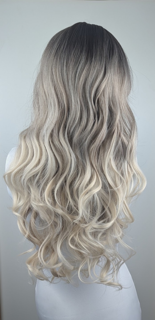 Storm - Lush Wigs UK A mix of dark brown and blonde sleek roots that blend into a sandy blonde colour. It is styled in big loose curls. The sleek long fringe is versatile to be worn to suit your look.