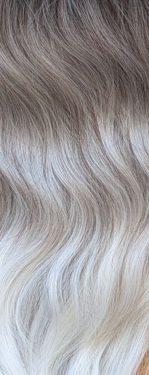 Storm - Lush Wigs UK A mix of dark brown and blonde sleek roots that blend into a sandy blonde colour. It is styled in big loose curls. The sleek long fringe is versatile to be worn to suit your look.