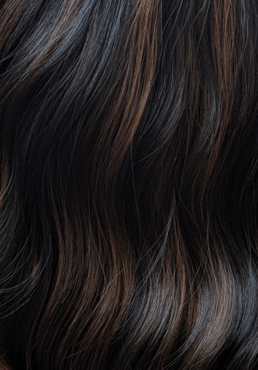 Swirl is defined by its warm coffee coloured low-lights, running throughout this very dark brown bob. Styled in gentle waves with a sleek blunt fringe.