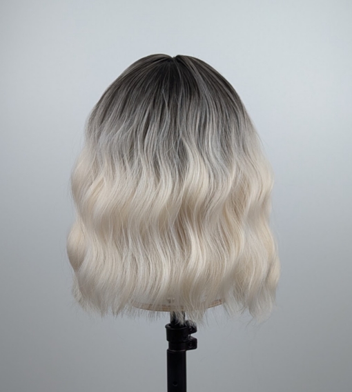 Outlet #149 - Lush Wigs UK A wig with brown shadowed roots that grow into this platinum blonde icy hue. Styled into a bob with loose waves. The fringe is sleek and blunt.