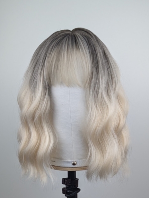 Outlet #149 - Lush Wigs UK A wig with brown shadowed roots that grow into this platinum blonde icy hue. Styled into a bob with loose waves. The fringe is sleek and blunt.
