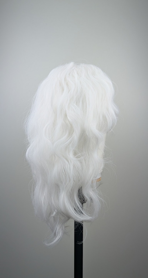 A snow white wig colour from roots to tips. Styled into a loose curl with layers around the face.