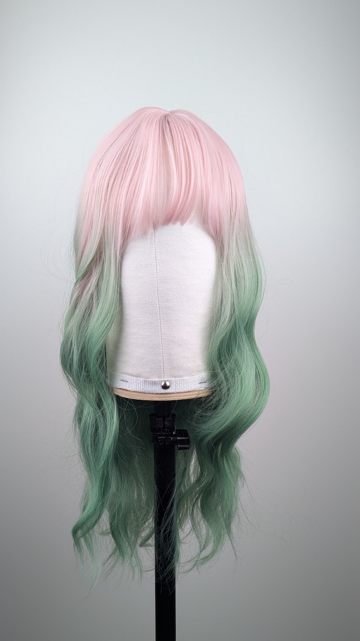 Outlet #239 - Lush Wigs UK A mix of pastel pink from the roots that melt into a dark green ombre. The style is sleek from the roots with a gentle wave for this one length long style. The fringe is long and sleek that can swept to the side or parted into curtain bangs.