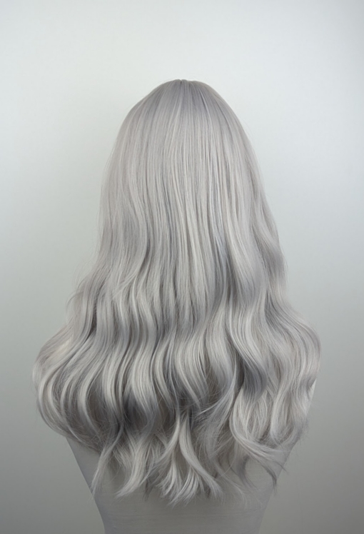 A Natural light grey/diamond blonde mix wig from roots to tips. A one length cut, styled in loose beachy waves with a sleek blunt fringe.